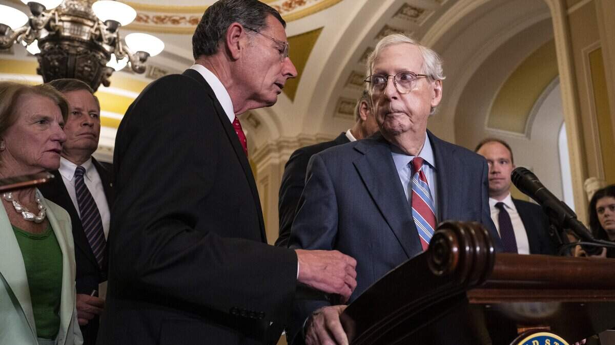 WASHINGTON, DC - JULY 26: (L-R) Sen. John Barrasso (R-WY) reaches out to help Senate Minority Leader Mitch McConnell (R-KY) after McConnell froze and stopped talking at the microphones during a news conference after a lunch meeting with Senate Republicans U.S. Capitol 26, 2023 in Washington, DC. Also pictured, L-R, Sen. Shelley Moore Capito (R-WV) and Sen. Steve Daines (R-MT)McConnell was escorted back to his office and later returned to the news conference and answered questions.  (Photo by Drew Angerer/Getty Images)