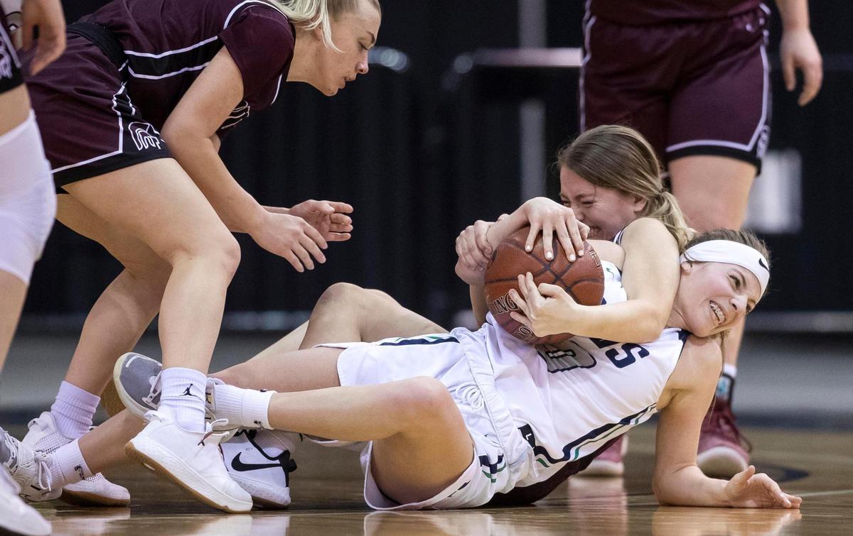 Mountain View guard Sierra Grizzle fights for a loose ball with Rigby’s Camryn Williams on Friday at the Idaho Center.