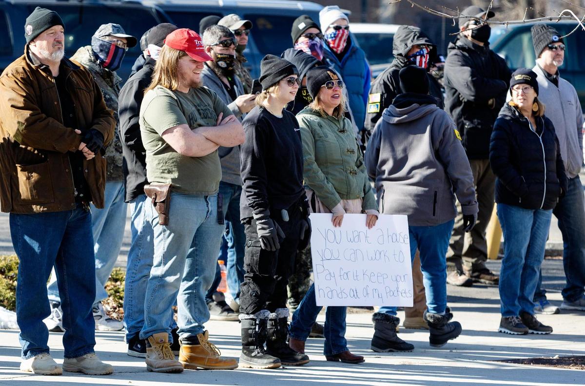 People from the Idaho Liberty Dogs stand across the street from a homeless demonstration to protest the gathering that resembles a tent city in downtown Boise on Saturday, Jan. 29, 2022, outside the former Ada County Courthouse.