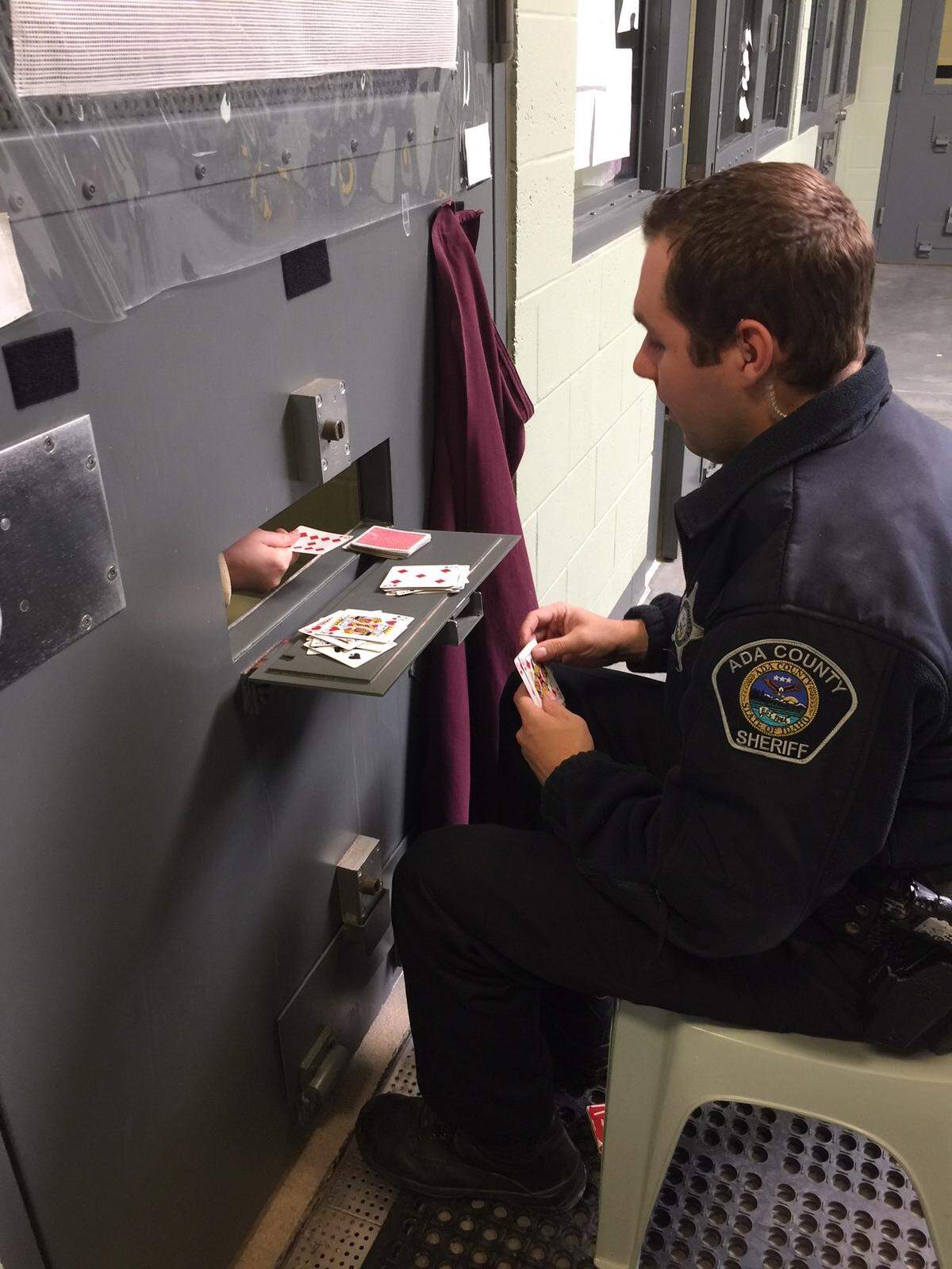 A deputy with the Ada County Sheriff’s Office is seen here playing cards with Katelyn Hodges in 2018 when she was in custody. Because of her disabilities and mental illnesses, Hodges must be housed alone in a secure health services cell. When time allows, deputies offer her crayons to color with or visit and play cards. She has the intellectual capacity of about an 8-year-old.