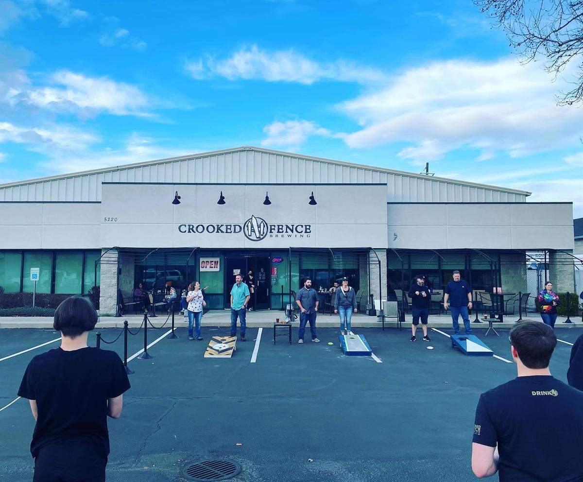 Beer drinkers enjoy games of cornhole outside Crooked Fence Brewing, which moved to its final location in 2018.