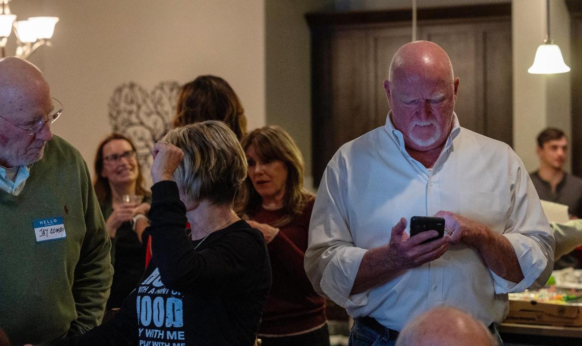 Eagle City Council President Brad Pike checks his phone for the latest election results during his election night watch party at his home in Eagle