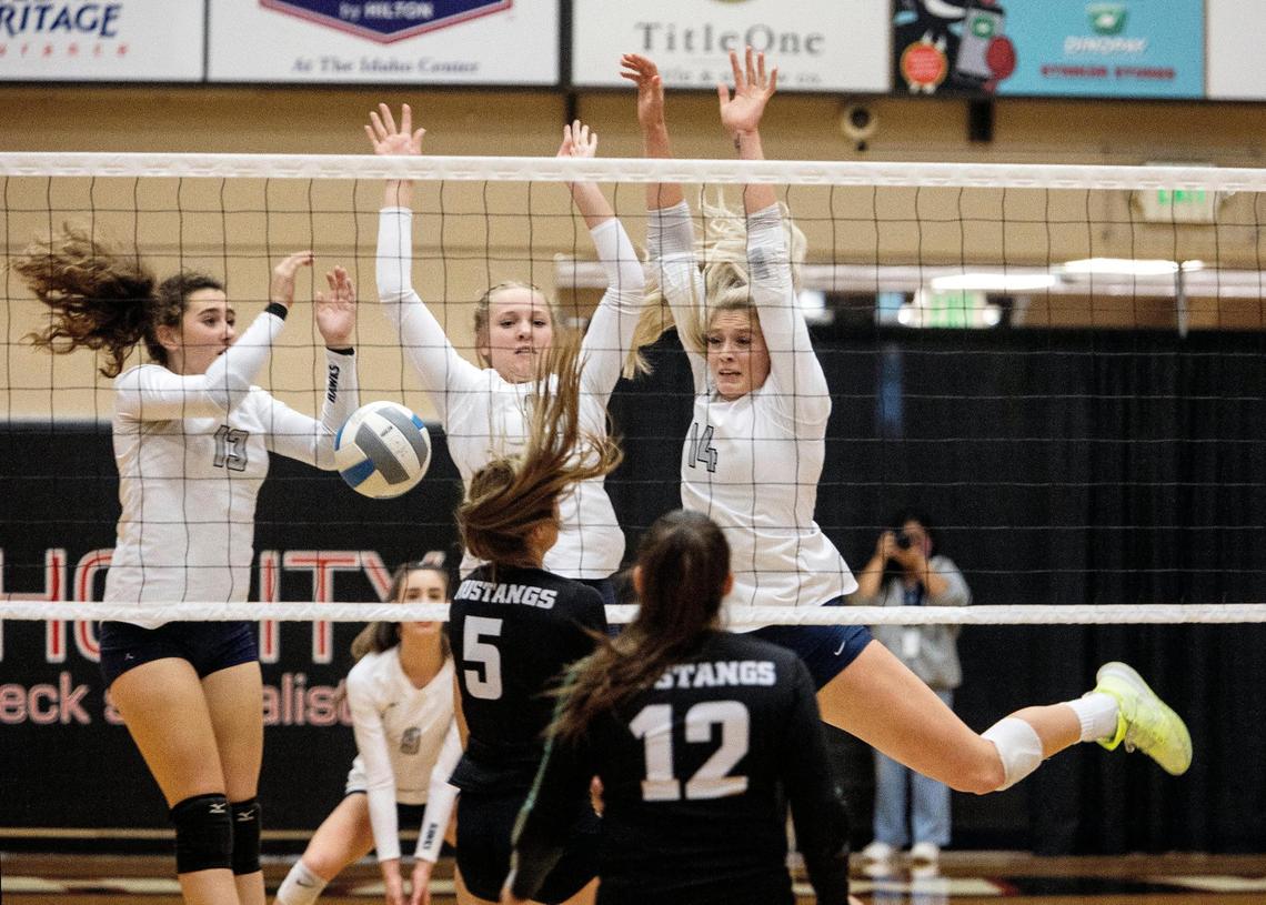 Skyview’s Brinley Perrine, center, rejects a shot from Eagle on Tuesday at Northwest Nazarene University’s Johnson Center in Nampa.