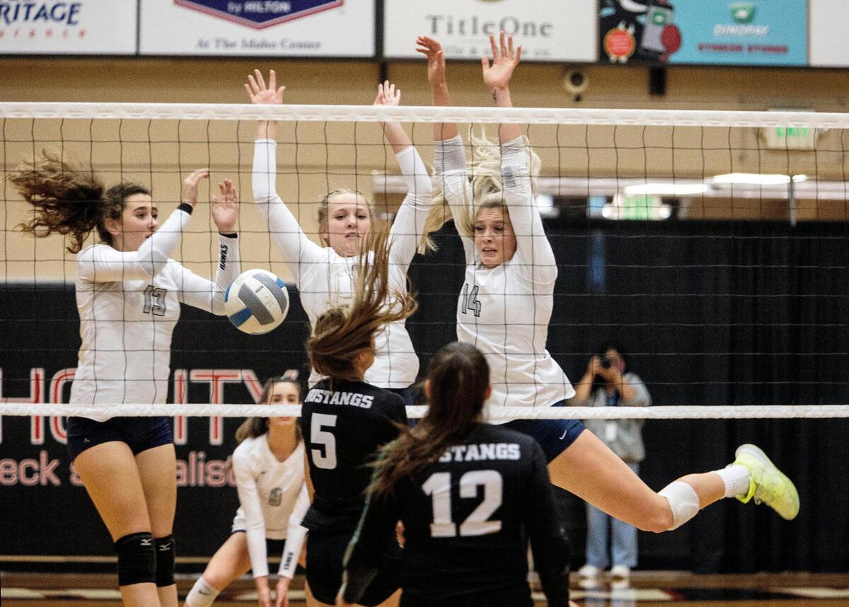 Skyview’s Brinley Perrine, center, rejects a shot from Eagle on Tuesday at Northwest Nazarene University’s Johnson Center in Nampa.