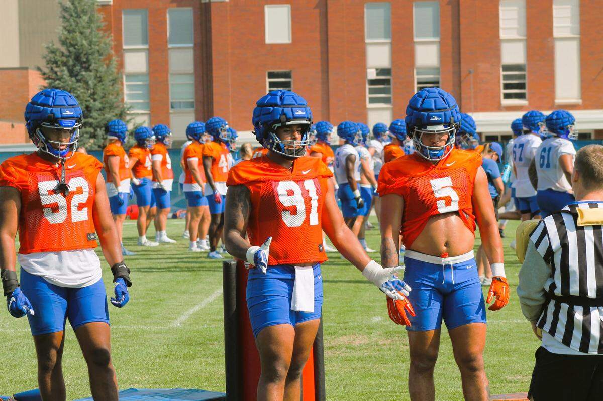 Boise State defensive ends Ahmed Hassanein (91) and Tavion Woodard (52) and edge rusher Jayden Virgin-Morgan run through a drill during fall camp. Woodard joined the team this year after five seasons at Ball State.