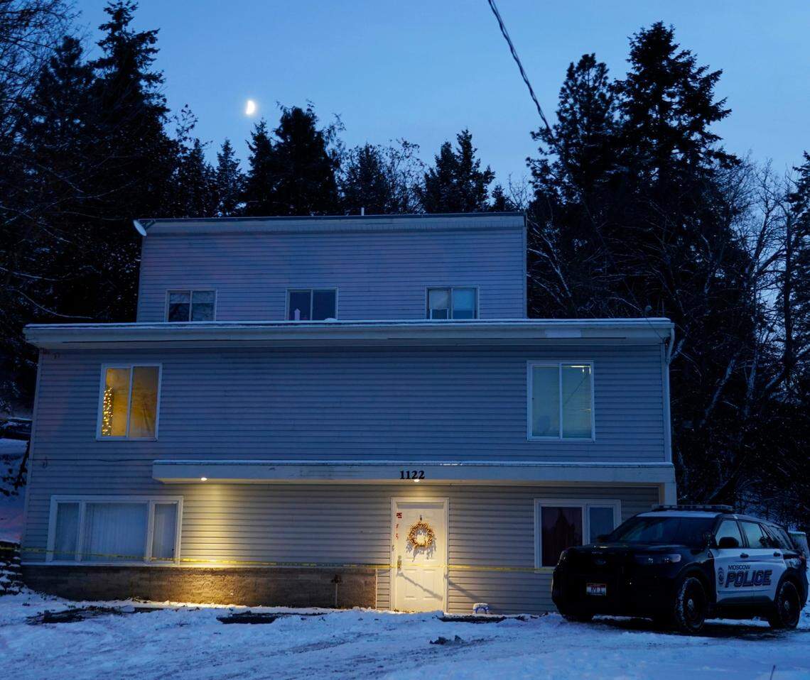 A Moscow police officer stands guard in his vehicle at the home where four University of Idaho students were found dead on Nov. 13.
