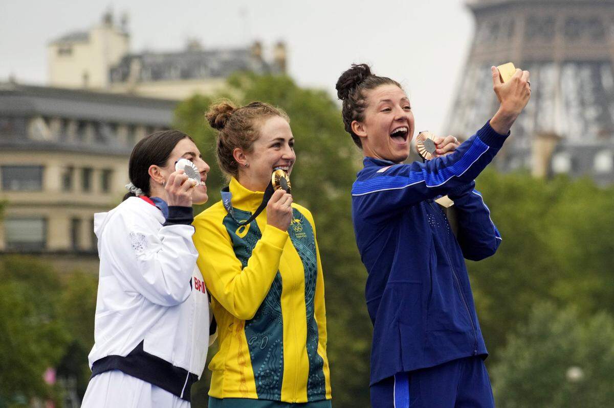 Jul 27, 2024; Paris, France; Anna Henderson (GBR) celebrates winning the silver medal, Grace Brown (AUS) celebrates winning the gold medal and Chloe Dygert (USA) celebrates winning the gold medal in the women's individual time trial road cycling during the Paris 2024 Olympic Summer Games at Grand Palais-Pont Alexandre III. Mandatory Credit: Andrew P. Scott-USA TODAY Sports