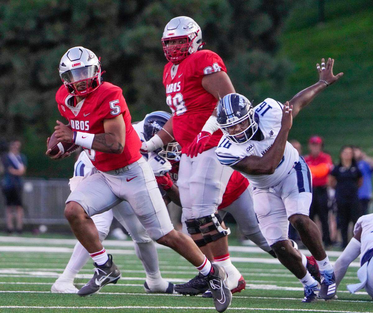 New Mexico quarterback Miles Kendrick, left, breaks away from a defender during the Lobos’ 41-0 win over Maine on Sept. 3.