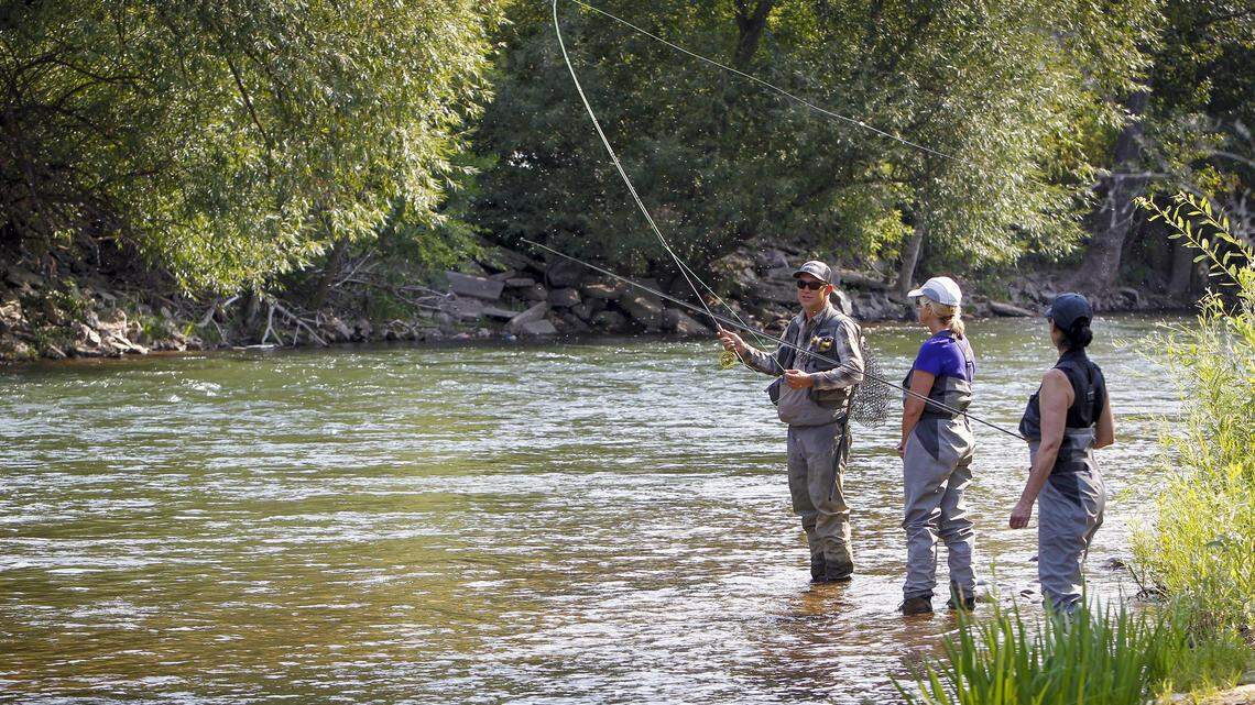 Chris Gerono, a casting instructor at Idaho Angler, explains to longtime friends Sheila McNeill and Karen Rooney how to fly fish on the Boise River on Saturday. The Minnesota women traveled to Idaho to visit a friend.