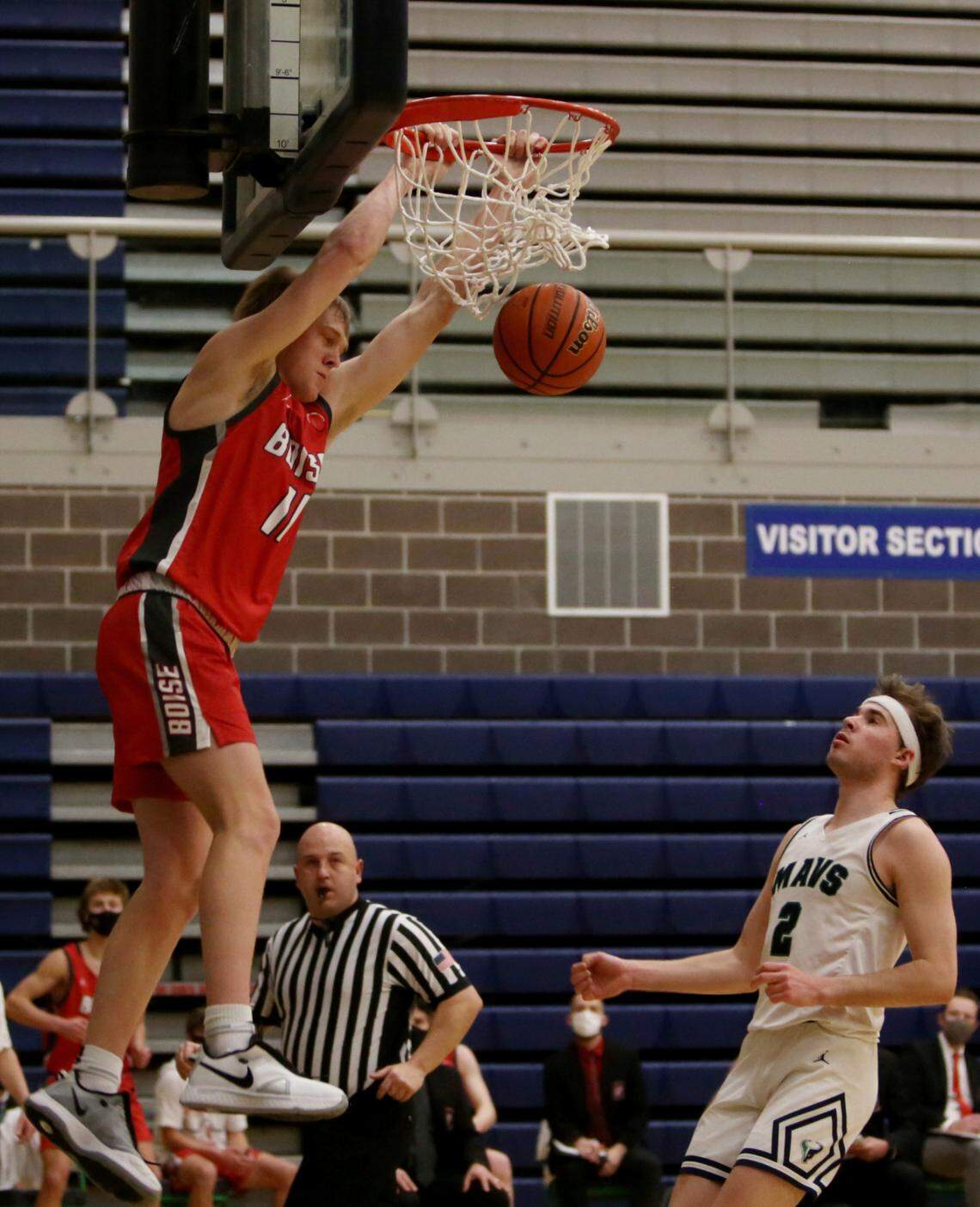 Boise’s Jack Payne throws down a two-handed dunk Tuesday at Mountain View High School in Meridian as the Mavericks’ Drew Carter look on.