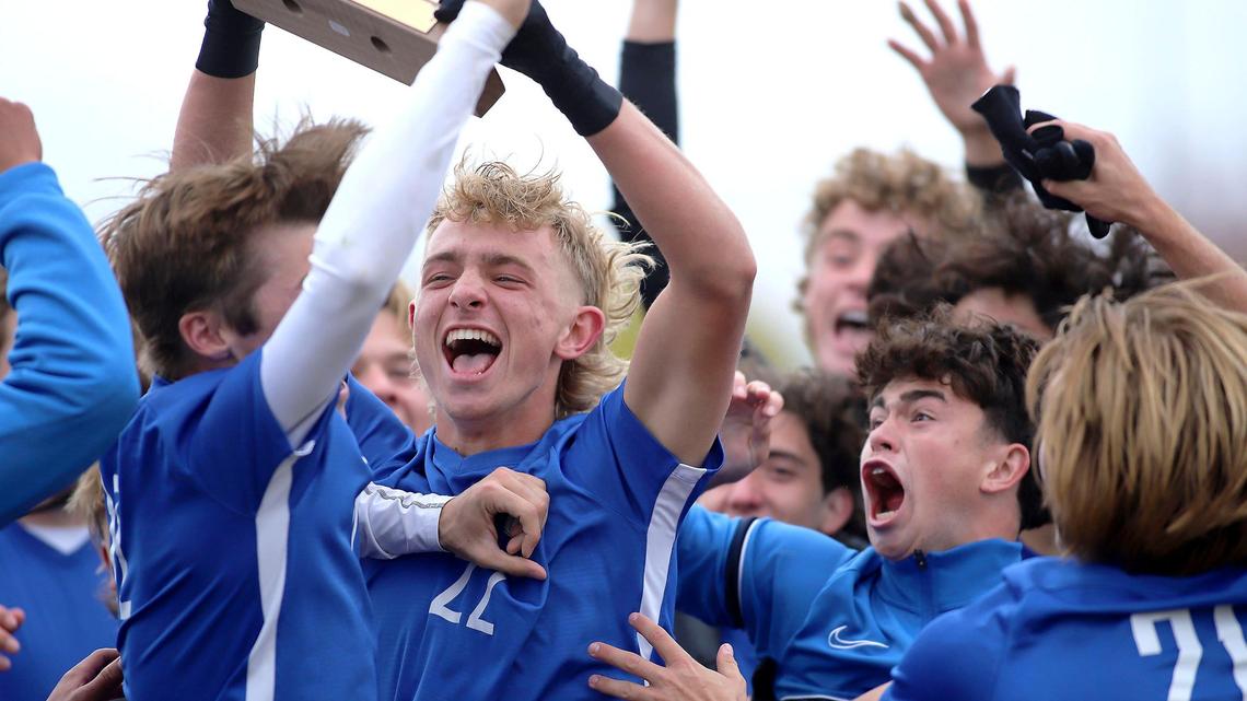 Timberline senior Jake Anderson holds up the trophy while the Wolves celebrate a 1-0 win over Boise in the 5A boys soccer state championship Saturday at Hillcrest High in Ammon.