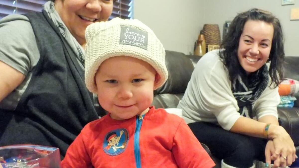 Reece Harper, in his Love Your Melon hat, with his grandmother, Keh McCracken, and mom, Mali McCracken, looking on.