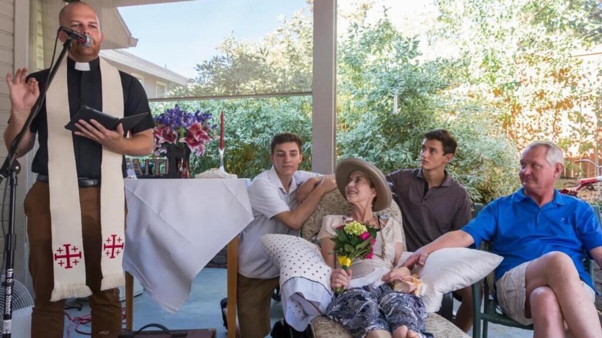 Dave Abels, pastor of Holy Trinity Church of Boise, performs a renewal of vows service for Marcia Panattoni and her husband, Michael Lindstrom. They are surrounded by their sons, Kyle and Alex.