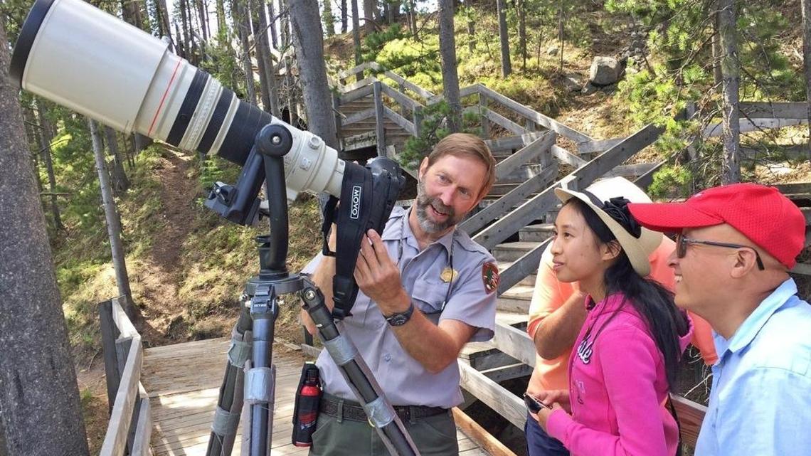 Yellowstone National Park photographer Jim Peaco gives Sunnyvale, Calif., tourists Amanda and Stephen Chou a lesson in shutter speeds while photographing harlequin ducks in the LeHardy Rapids section of the Yellowstone River in Yellowstone National Park.