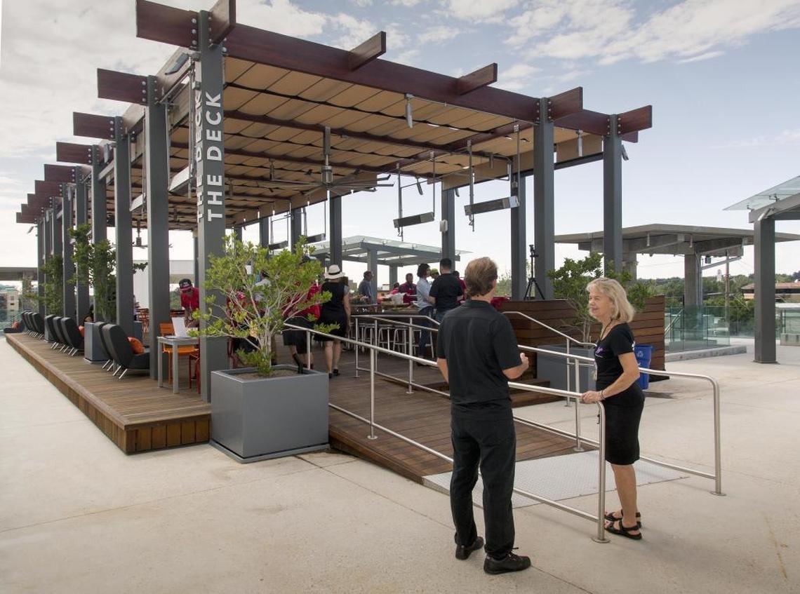Executive director Maggie Soderberg, foreground, unveiled the most recent space to open at JUMP. The Deck rooftop patio offers comfortable seating, multiple conversation areas, heaters and a fire pit for when it’s chilly.