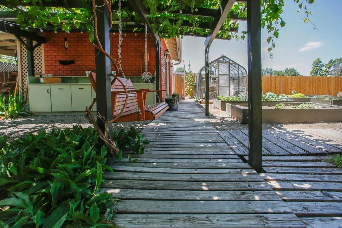 Brittney Scigliano’s converted a backyard brick outbuilding into a comfortable retreat, complete with a porch swing and gardening table.