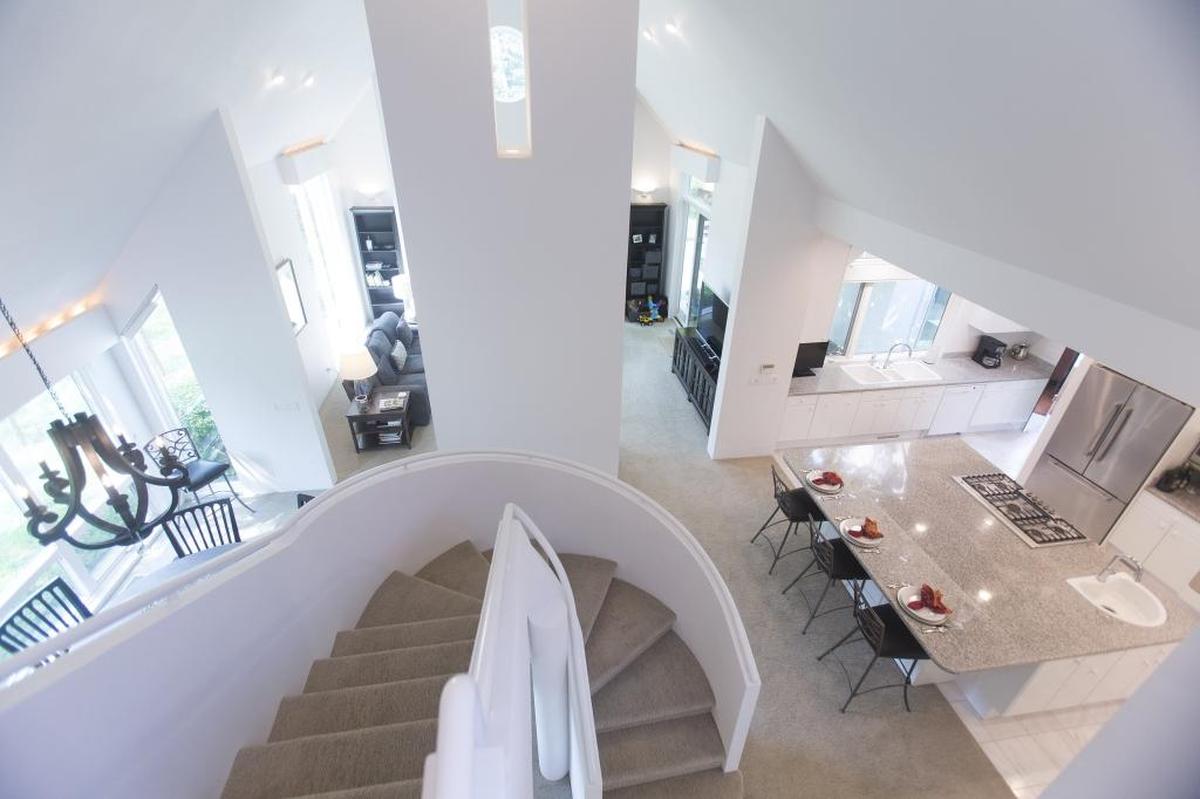 This view from the spiral staircase shows the integration of the three living spaces — kitchen, informal dining room and family room —where the family spend much of their time.