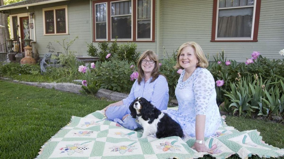 Cousins Joanne Hoppe, right, and Garnette Edwards, with Hattie. Their grandparents founded Edwards Greenhouse, and behind them is their grandparents’ original home — and their grandmother’s original peonies, which Hoppe revived.