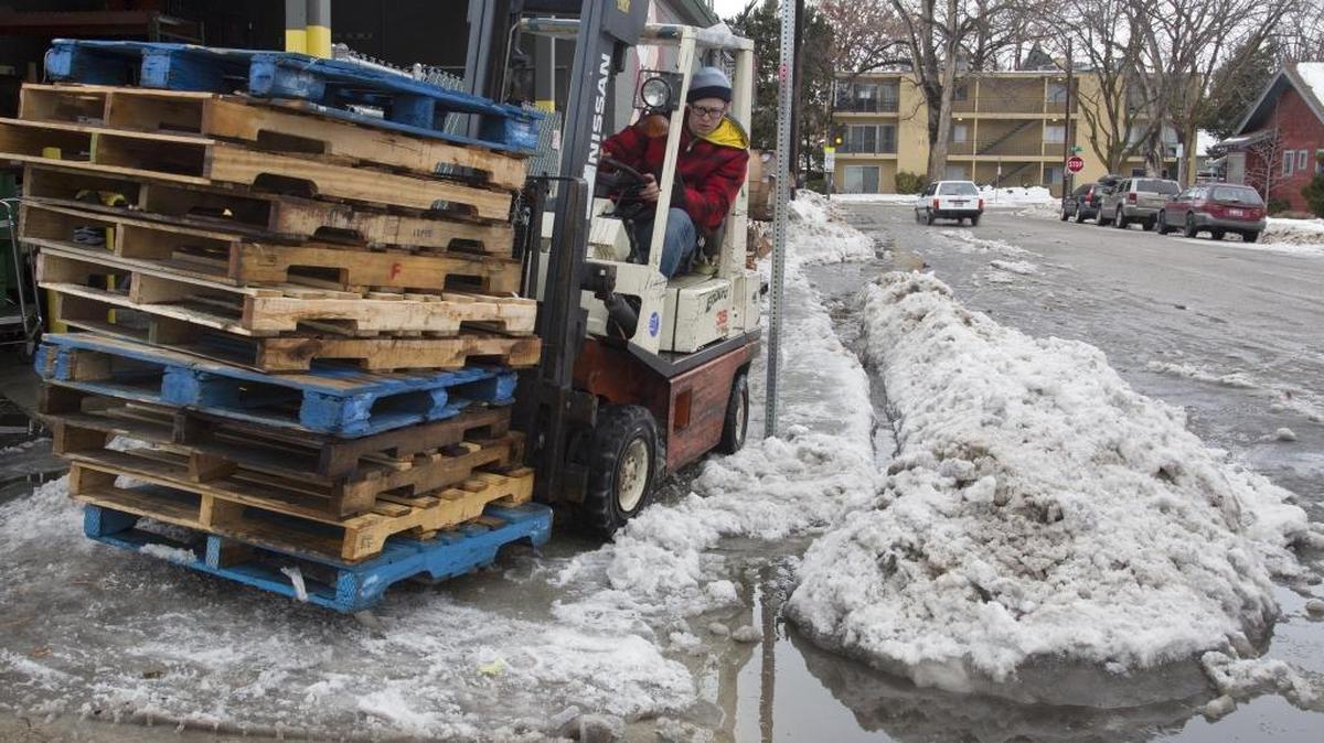 Lance Brown, grocery manager at the Boise Co-op, moves pallets with a forklift after clearing out snow and slush on Monday. Brown and other employees were forced to dig trenches on two sides of the store to help drain snowmelt.