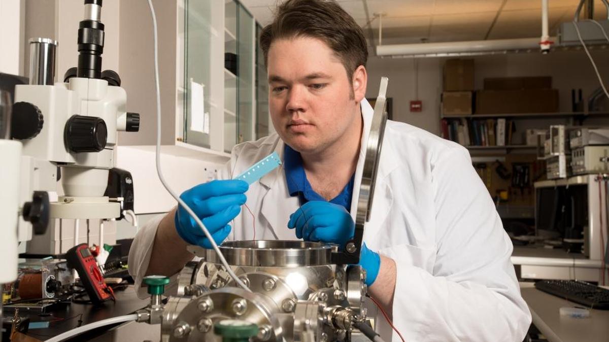 Graduate student Peter Bumbarger studies the test structure for a plasma medicine experiment at Boise State University.