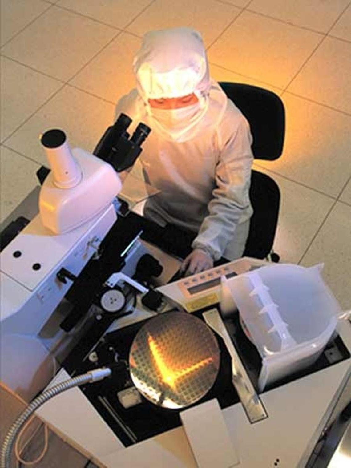 A United Microelectronics Corp. worker performs a quality-assurance check on a 12-inch wafer in one of the company's Taiwanese fabs.