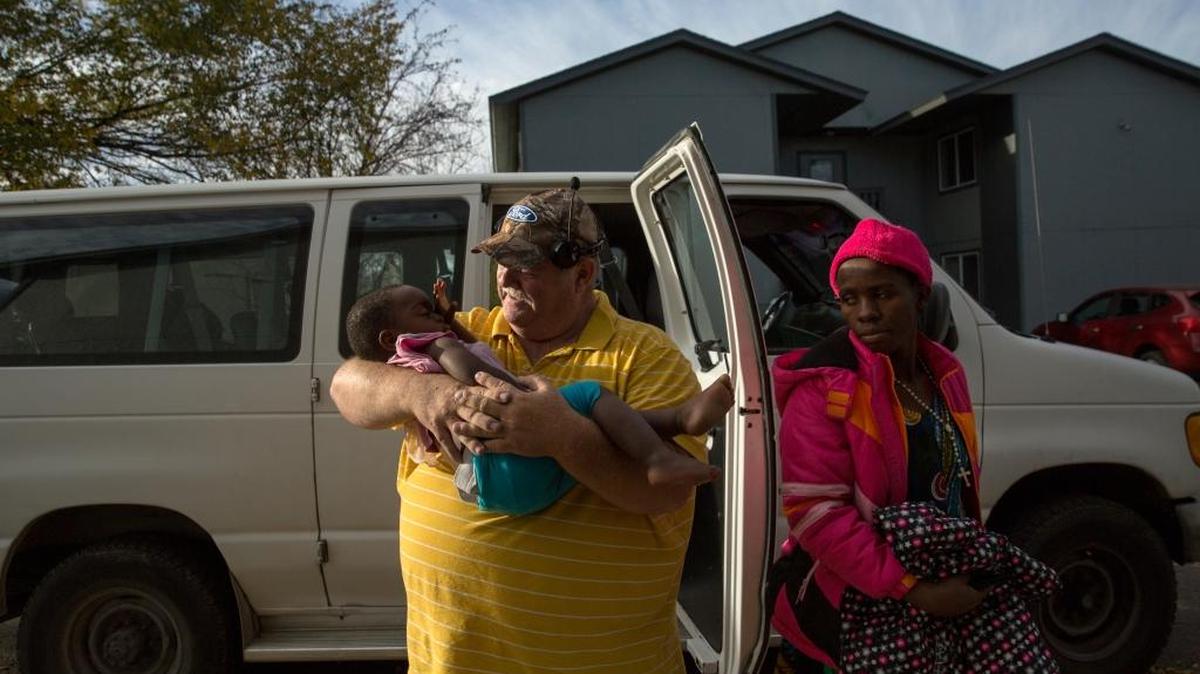 Bob Schmidt, a driver for a Twin Falls refugee center, holds Marceline Baruani's child.