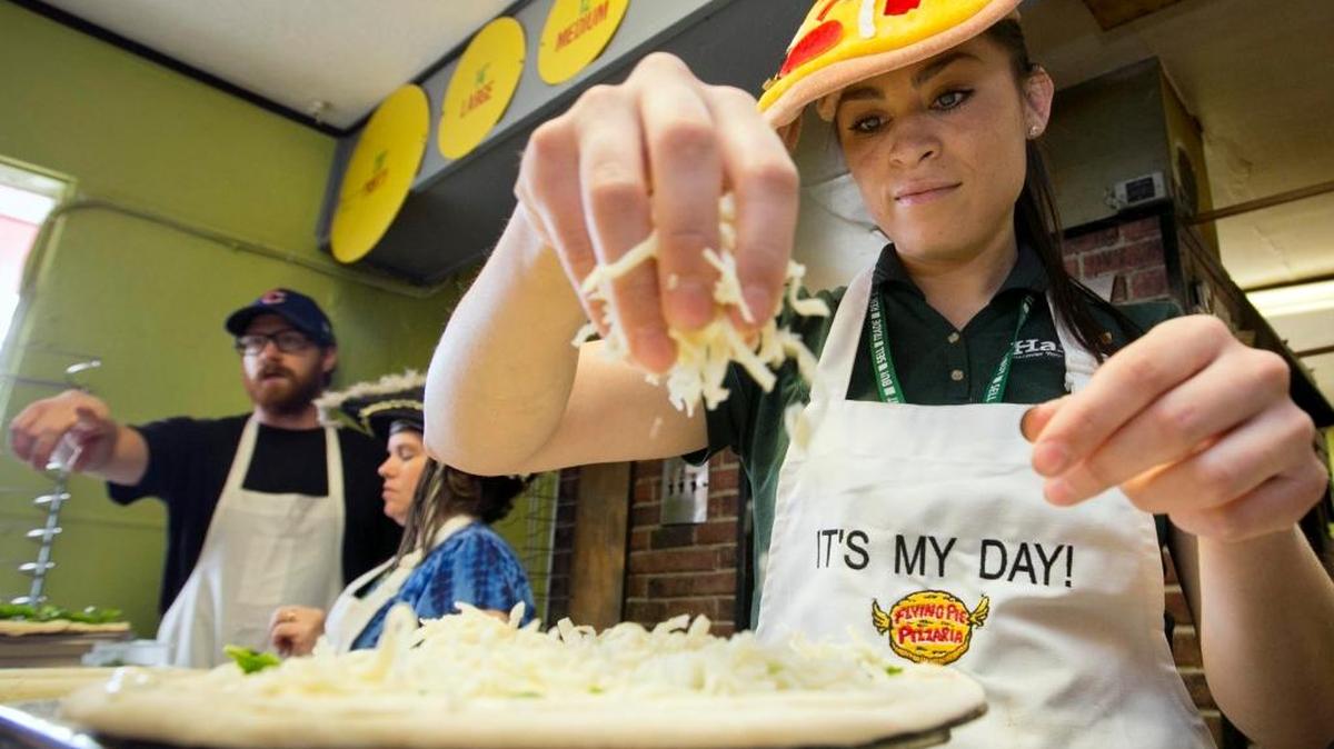 Rosa Sandoval gets generous with mozzarella cheese on her own custom-made pizza during a 2013 “Your Day” promotion at Flying Pie Pizzaria on Fairview Avenue in Boise.