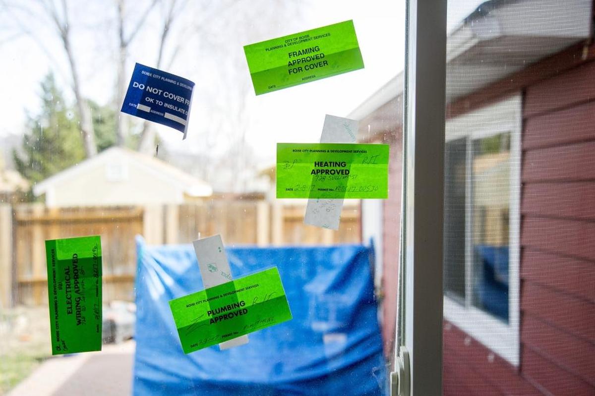 Approved inspection stickers from Boise’s Planning and Development Services office pepper the window of a house being remodeled at a Levco Builders job site near Broadway Avenue in Boise.
