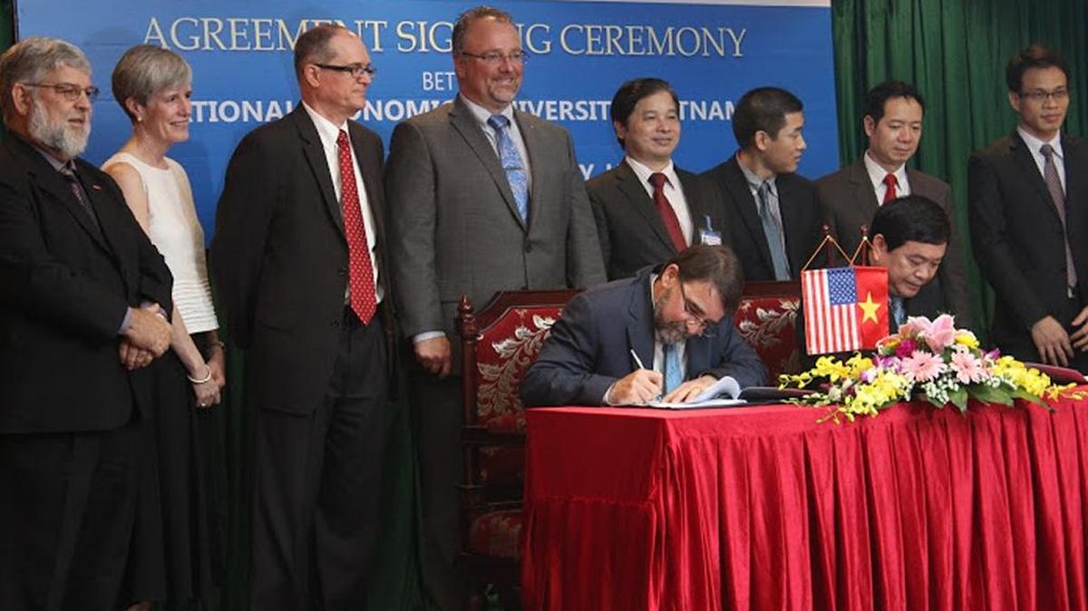 Boise State University Provost Martin Schimpf and National Economics University President Tran Tho Dat sign the agreement in Hanoi.