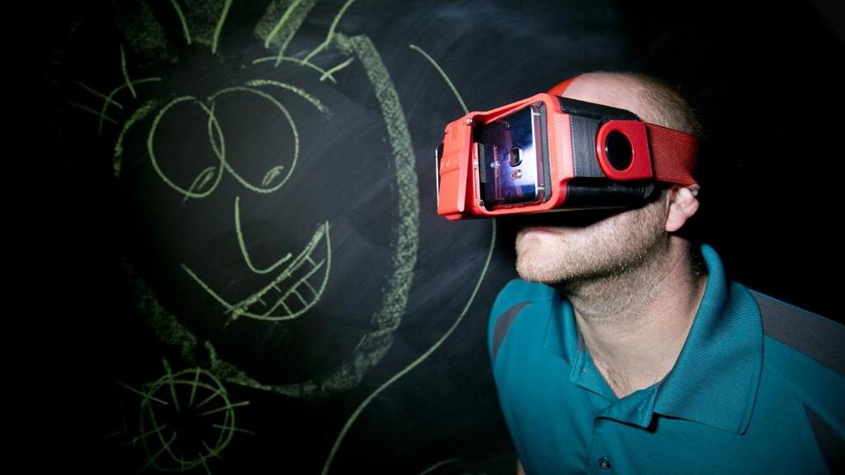 Dan Thurber, founder and president of IonVR, uses one of the company's virtual reality headsets in September. The headset will be compatible with most kinds of smartphones.