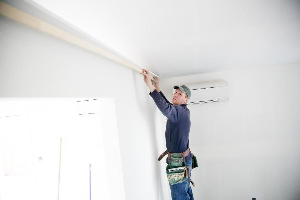 David Philllips installs a piece of trim. Levco owner Joe Levitch says house flippers do more superficial work than remodelers. “I add value by tearing houses apart and putting them together properly,” he says.