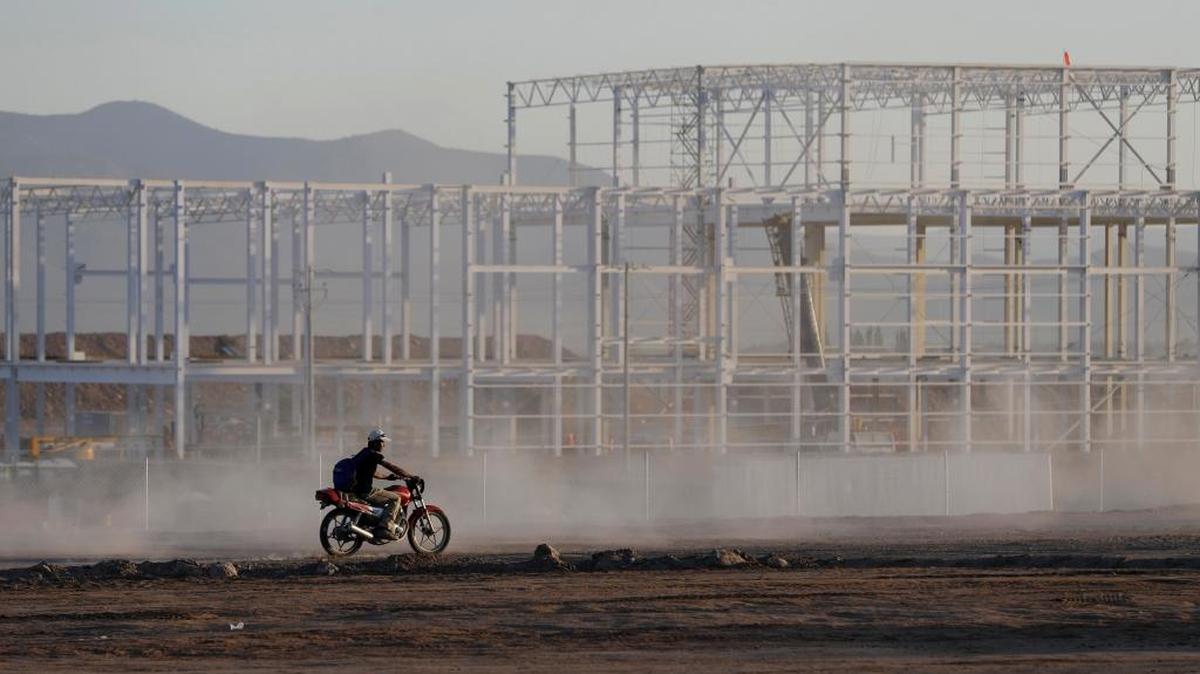 A worker at a near-deserted Ford construction site in Mexico rides past an unfinished building on Jan. 4, one day after Ford announced it was canceling plans to build a plant there. Ed Lotterman says companies like Ford that do business in multiple countries have wide latitude in estimating values of their goods for transfer pricing, an essential accounting step.