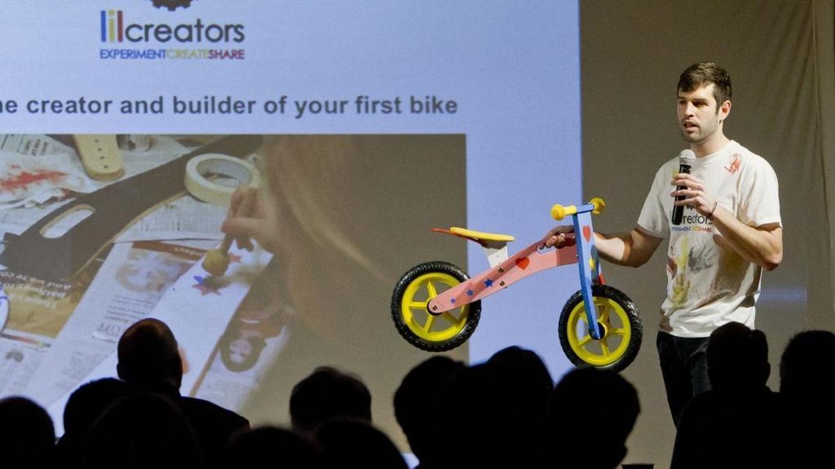 John Kortibarria, founder of the startup lilcreators,holds a bike made from a kit that can be decorated and assembled by children and parents. He was the first of 20 entrepreneurs to make presentations at the Challenge Cup at Trailhead on Wednesday.