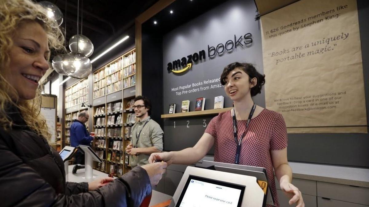 Kirsty Carey, left, gets ready to swipe her credit card for clerk Marissa Pacchiarotti at the 2015 opening of Amazon’s first bookstore in Seattle. The company now has 18 Amazon Books stores across the nation and had planned to open one in Meridian but has apparently abandoned those plans.