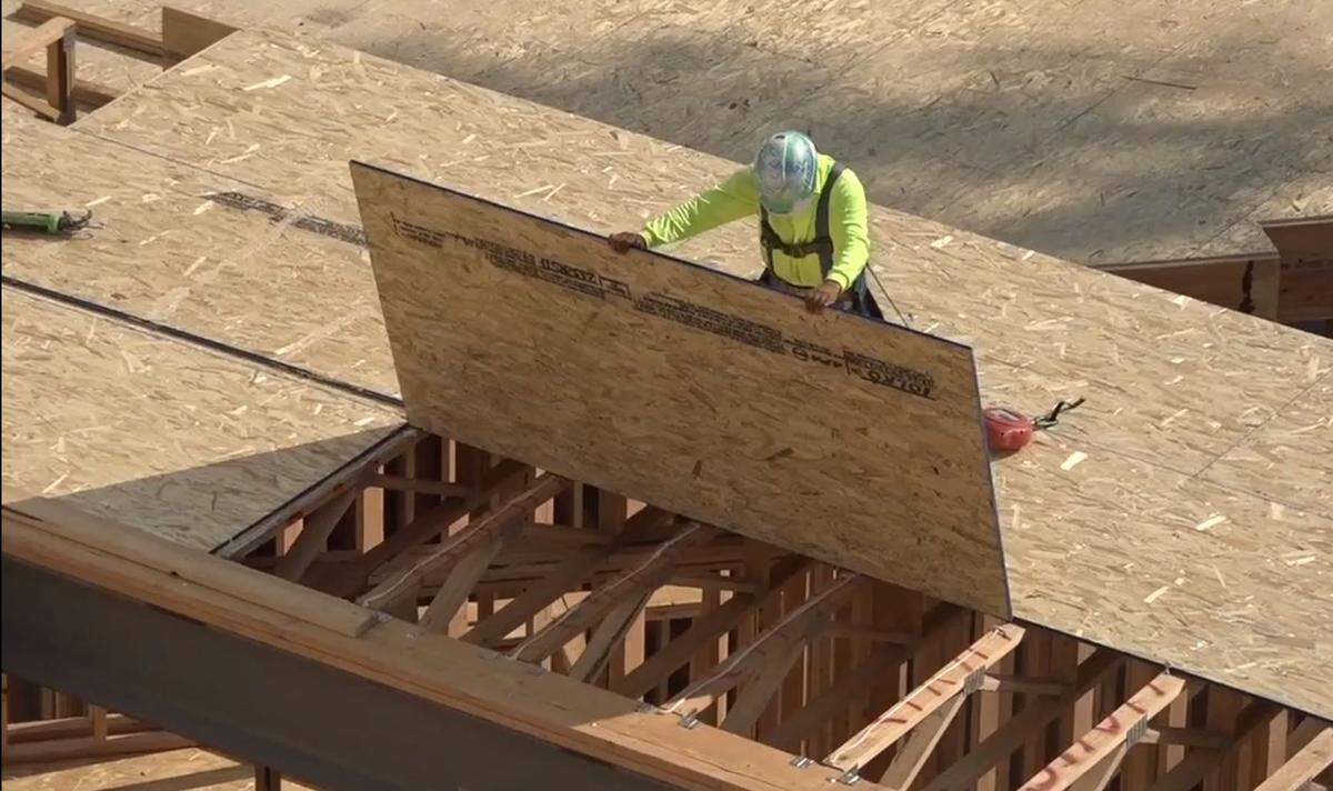 A worker drops a sheet of plywood into place at the Park Place Apartments being built by Okland Construction Co., of Salt Lake City, at 749 E. Park Boulevard, near the Boise State University campus.