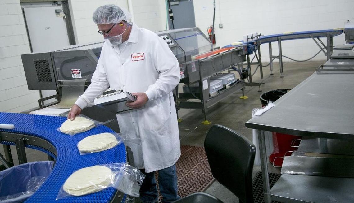 Dale Orcutt, assistant plant manager, inspects tortillas as they roll off the assembly line at Fresca Mexican Foods. The company offers products that are kosher certified, halal certified and free of genetically modified ingredients.