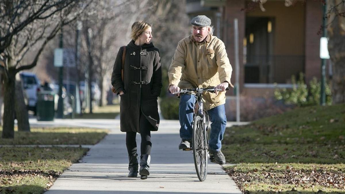 John Laufenburger rides his bike in Downtown Boise beside his daughter, Chelsea. Laufenburger has back problems and finds cycling is easier on his back than walking. Last summer, while on his bike, he was hit by a car and ended up in the emergency room with a concussion and no health insurance.
