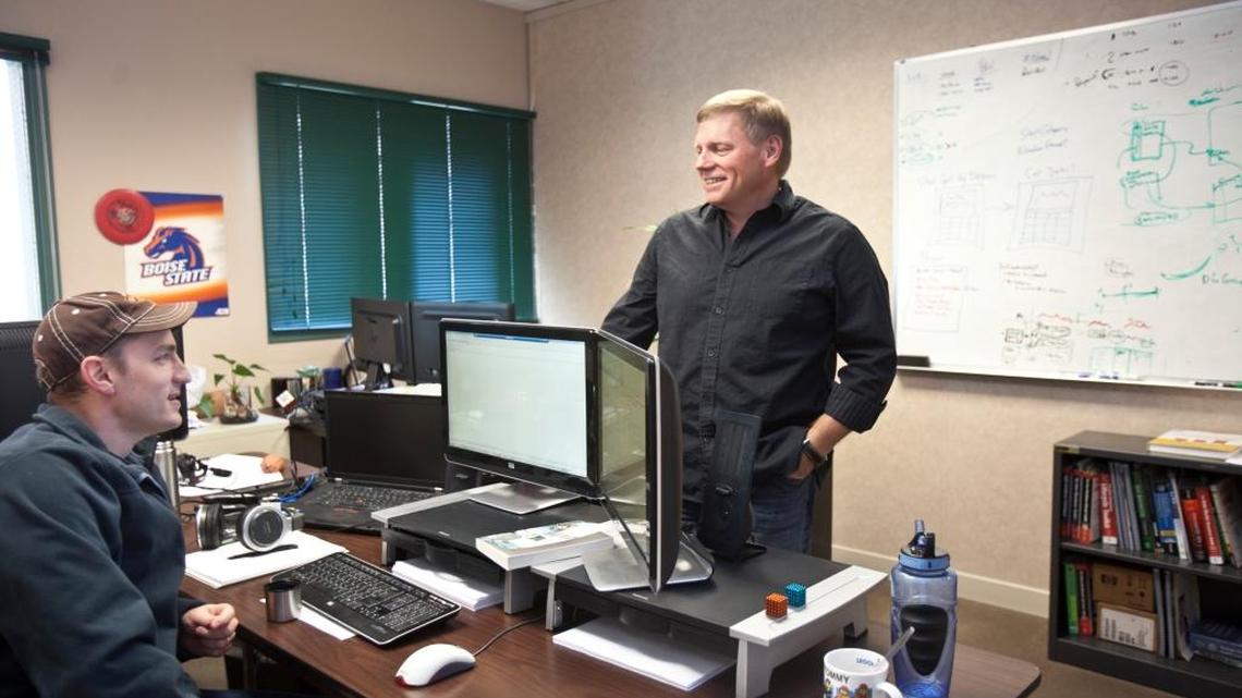 Bob Lokken, CEO of WhiteCloud Analytics, talks with employee Lane Schmelzenbach at the company's downtown Boise offices in September 2012.