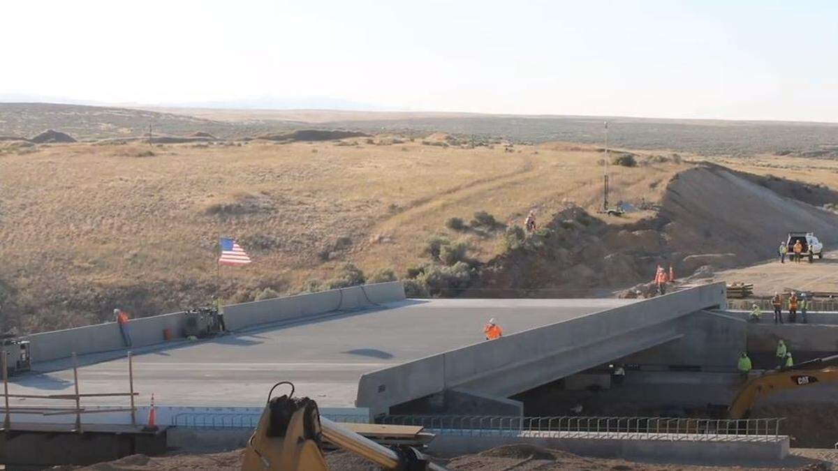 Highway-construction workers slide the Blacks Creek Bridge’s new eastbound lane into place in July 2020. The bridge was built to the left of this image.