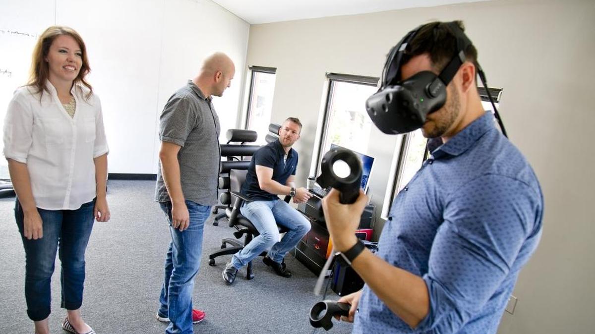 Jessica Whiting, director, (left to right), Dan Thurber, inventor, Ryan DeLuca, CEO and co-founder, and Preston Lewis, co-founder & chief design officer, demonstrate a virtual reality set up at the offices of Blackbox VR in Boise, Idaho.