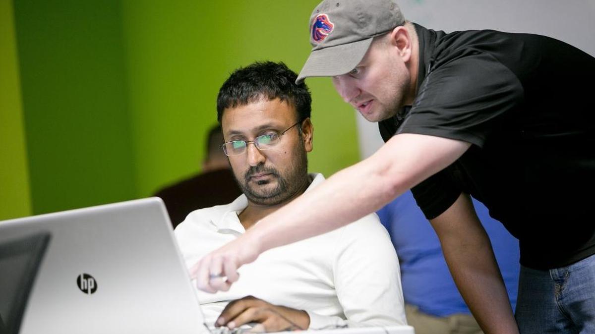 BoiseCodeWorks instructor Matt Overall (right) helps student Ranjit Ahluwalia with a JavaScript exercise during a BoiseCodeWorks bootcamp in Garden City in September.