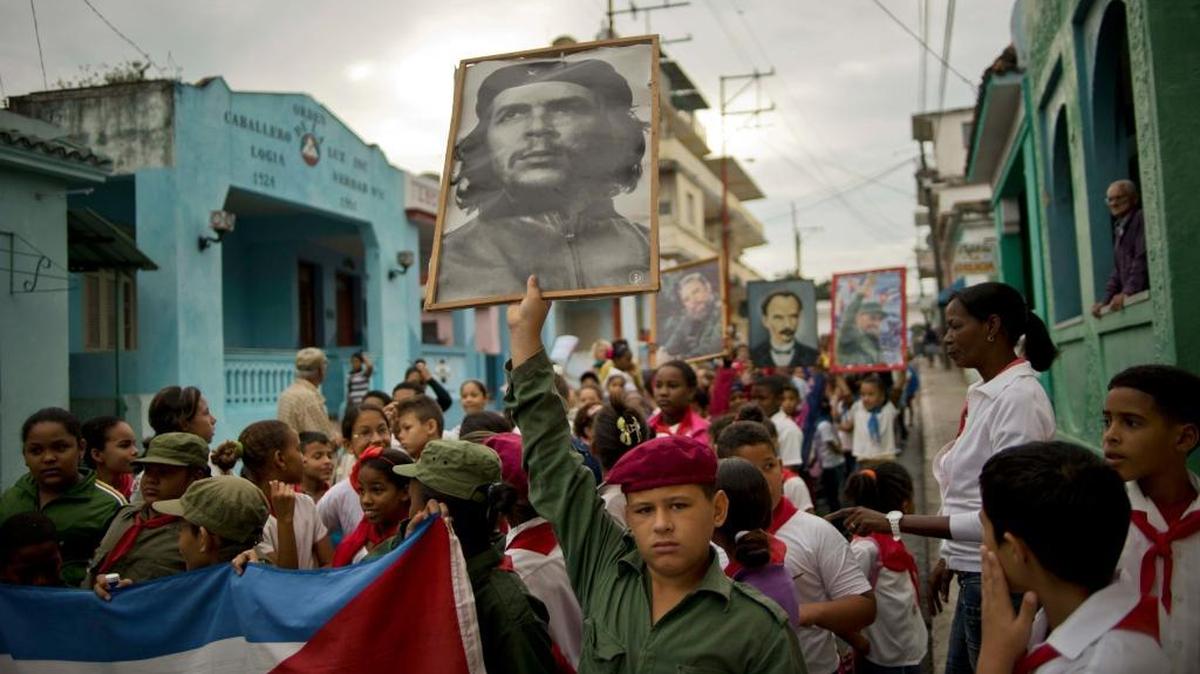 A child holds a picture of revolutionary hero Ernesto “Che” Guevara as others carry portraits of Fidel Castro and independence hero Jose Martí during a caravan Jan. 8. The caravan marked the 57th anniversary of the arrival of Fidel Castro and his rebel army in the outskirts of Havana after toppling dictator Fulgencio Batista. Cuba today suffers from an exodus of high-initiative, highly intelligent people, Ed Lotterman writes.