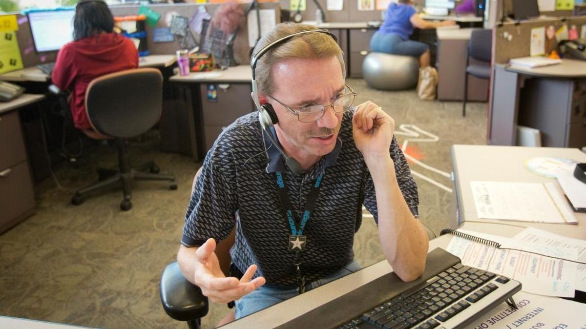 In this 2013 photo, DirecTV employee Bill Dickey takes incoming customer calls at the call center at 5800 N. Meeker Drive.