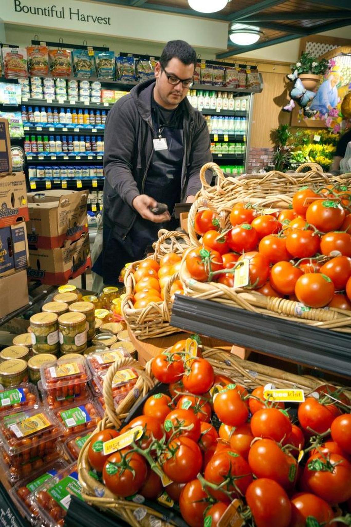 Albertsons produce clerk Matt Lerice stocks avocados at the State and 16th Street store in March 2013.