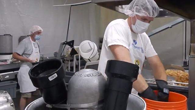 A worker at Teton Valley Brands’ Nampa potato-chip plant gathers potatoes from a bucket for slicing with the skins on.