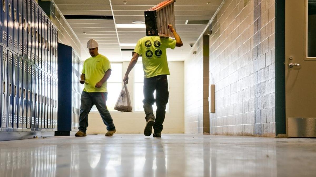 Construction workers carry equipment through a hallway at Victory Middle School in Meridian in June. The $27 school is slated to open for the coming school year.