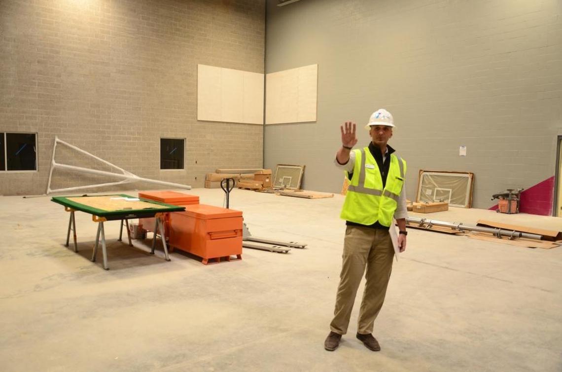 Mike Kapuscinski, executive director of the South Meridian Family YMCA, points out features of one of two gyms. This gym is connected to Hillsdale Elementary. Students will have access during the school day for physical education classes, while YMCA members will be able to use it after school, on weekends and during school breaks.