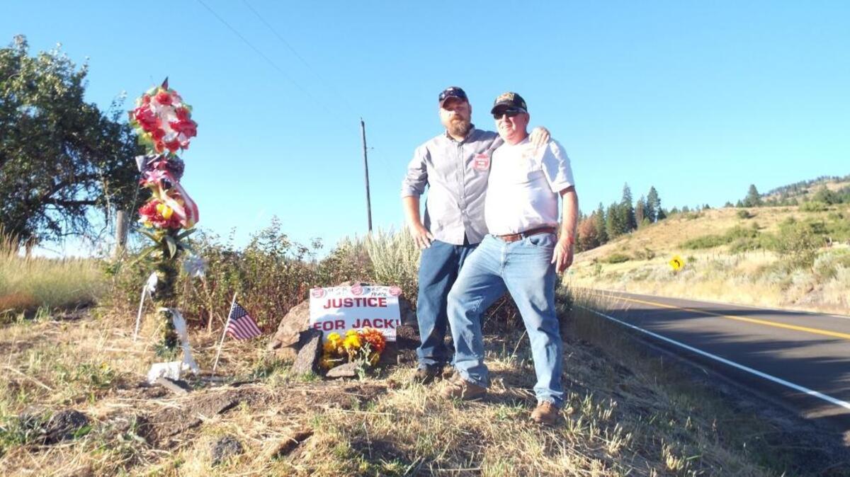 Justice for Jack organizer Michael McLaughlin, right, and supporter Tom Landweer stand at a memorial near where rancher Jack Yantis was killed on U.S. Highway 95 north of Council.