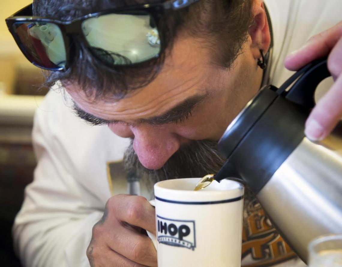 Jamie Harrell, who is legally blind, carefully pours coffee into his mug, watching up close where he can see more detail. His wife, Nena, tells him when he’s reached the top.