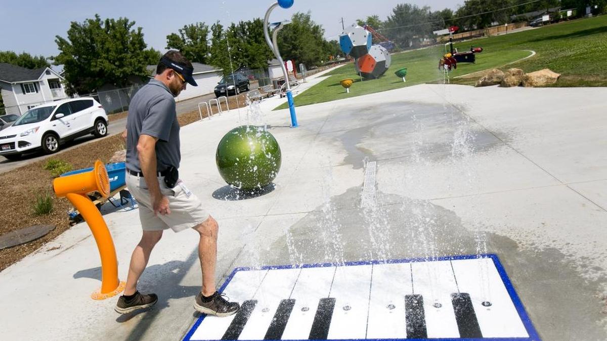 Toby Norton, Planning Manager for the city of Boise tests a musical piano on the new splash pad at Comba Park, which was developed with extensive help from the city’s Neighborhood Reinvestment Grant program. The park, which also features a playground, opened August 7, 2014. Mayor David Bieter used Comba Park, which was built as the venue for his announcement of this year’s Neighborhood Reinvestment grants.